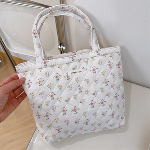 Close-up of floral quilted tote bag featuring a simple wish label and soft texture