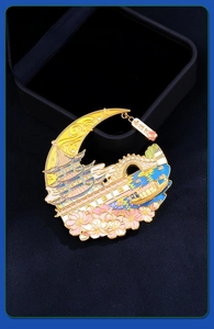 Detailed view of crescent metal magnet with gold pagoda, stone bridge and floral enamel