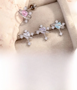 Macro shot of titanium steel heart planet earrings with zircon stones in a jewelry box