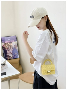 Detail of yellow PVC jelly bag featuring diamond lattice pattern and pearl handle straps