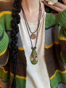 Handmade Bohemian water drop pendant necklace with bow and tassel details on model
