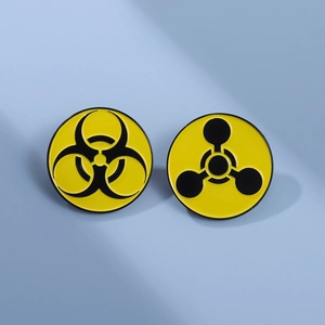 Creative biohazard and radiation warning enamel pins on a light blue background