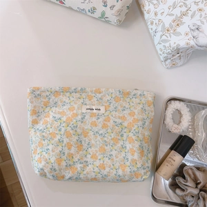 Detail of floral makeup bag with yellow patterns and simple wish fabric label