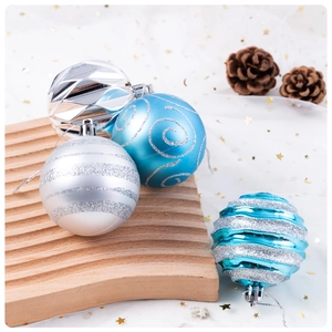 Close-up of blue and silver Christmas ornaments with glitter patterns on a wooden tray