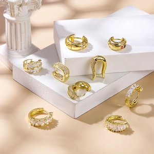 Chic gold geometric zircon huggie earrings collection on white display blocks