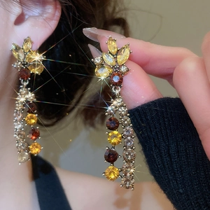 Detail of vintage flower tassel earrings with sparkling crystals on model
