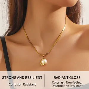 Close-up of gold snake chain necklace featuring a pearl pendant with crystal accents