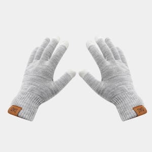 Detail of grey knitted touchscreen gloves featuring an embossed leather DAD label