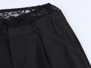 Detailed close-up of women's black trousers featuring intricate lace patchwork on the waist