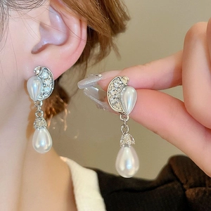 Vue détaillée des boucles d'oreilles perles argentées et diamants micro-pavés