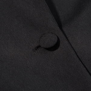 Macro shot of twill fabric texture and fabric-covered button on a black jacket