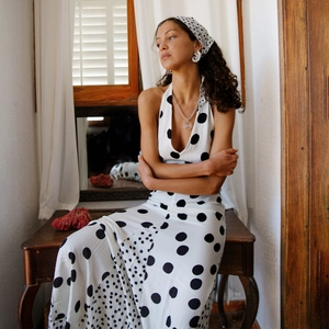 Detailed view of white polka dot dress with halter neck and matching headband accessory