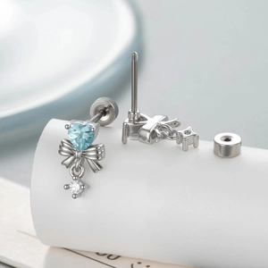 Orecchini a perno in acciaio al titanio con fiocco cuore zircone blu e chiusura a vite