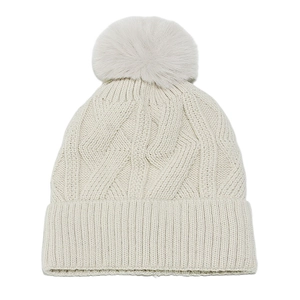 Close-up of cable knit texture and faux fur pom-pom on beige winter beanie hat