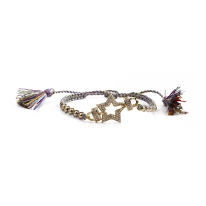 Nahaufnahme eines gewebten Armbands mit goldenem Sternanhänger und bunten Seidenquasten