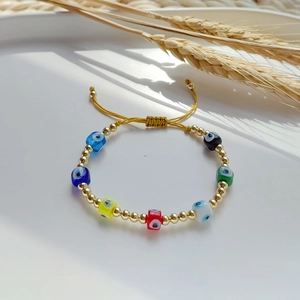 Detailed macro view of colorful evil eye beads and golden spacers on adjustable bracelet