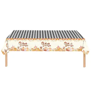 Detail view of Thanksgiving tablecloth with maple leaves, pumpkins, and black white plaid pattern