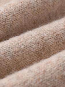 Detailed macro view of beige cashmere knit fabric with soft texture and high-quality weaving