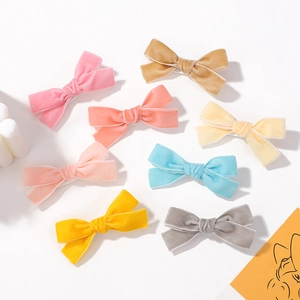Set of eight colorful velvet bow hair clips for girls in various candy-colored shades