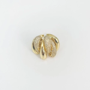 Detailed close-up of golden irregular twisted ring with multi-layered sparkling zircon pavé