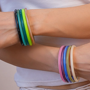 Close-up of model wearing colorful acrylic resin bangles in stacked fashion style