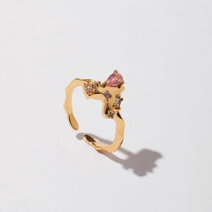 Macro detail of golden irregular lava ring featuring pink drop zircon and purple stones