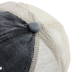 Detailed close-up of dark grey washed cotton twill fabric and beige mesh on the baseball cap