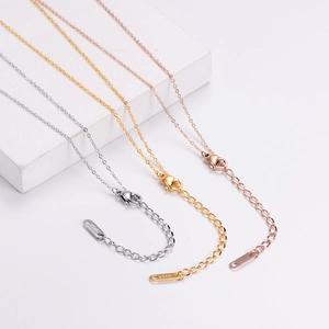 Detail view of 18KGP engraving on lobster clasp and extension chains of three-tone necklaces