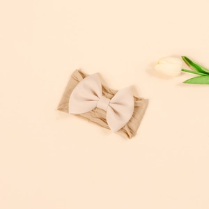 Detail of high-elasticity nylon baby headband with a soft pink 3D bow and knit texture