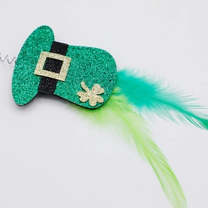 Detail of St. Patrick's Day green glitter hat headband with clover and feather accents