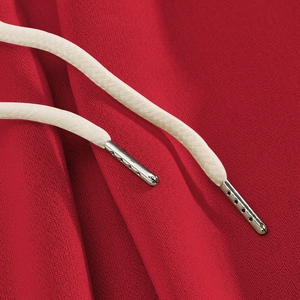 Detailed close-up of red knit fabric with cream drawstring and metal aglets
