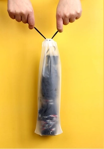 Makro-Detail von Händen, die einen mattierten Kordelzugbeutel für Regenschirme festziehen