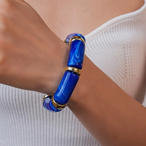 Detailed close-up of blue marble acrylic bamboo bracelet with gold metal spacers