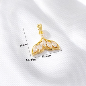 Detail showing 20mm x 17.5mm gold fishtail pendant with sparkling white zircon stones