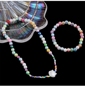 Colorful ABS pearl necklace and bracelet set with a shell pendant on a black background