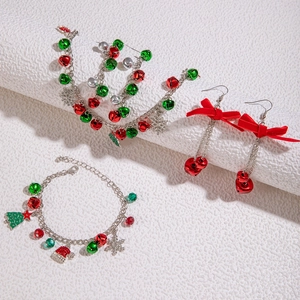 Detail of Christmas beaded bracelet and bell earrings in vibrant red and green