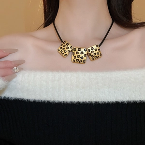 Nahaufnahme einer Vintage Gold-Halskette mit Leopardenherz und Kristallen am Model