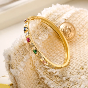 Brazalete abierto dorado de 18K con cristales coloridos y flores de esmalte blanco
