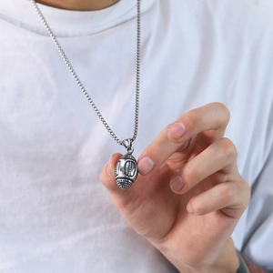 Close-up of a silver 3D football pendant necklace worn on a classic steel chain