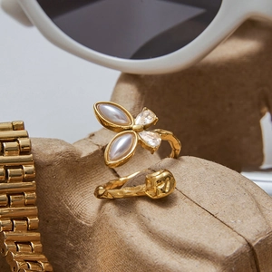 Gold butterfly ring with pearls and hammered texture on a stylish fashion accessory background