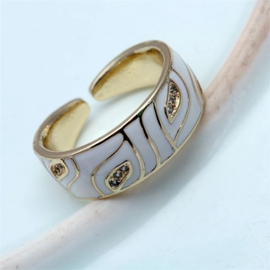 Detailed macro view of gold open ring with white enamel eye pattern and zircon inlay