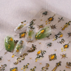 Nagelaufkleber im Barock-Stil mit goldenen Sternen und Sonnenmotiven auf Smaragdgrün