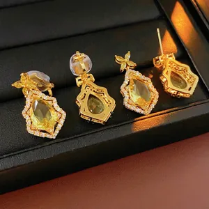 Elegant yellow pear-shaped drop earrings with gold plating and sparkling halo crystal studs