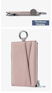 Detail view of slim pink lychee leather coin purse thickness compared to a coin