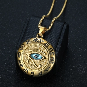 Vintage gold Eye of Horus pendant necklace with blue gemstone on black background