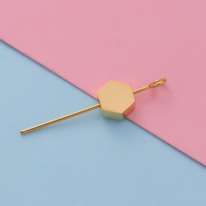 Detailed view of a gold hexagonal metal bead accessory on a fine rod with small loop