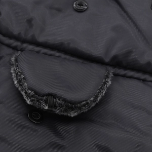 Close-up of black winter hat fabric with faux fur trim pocket and button detail