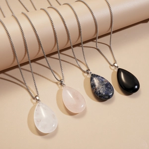 Detail of four teardrop natural stone pendants on silver chains in multiple colors