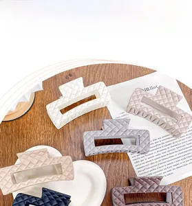 Detail showing various colors of quilted texture hair claws with matte finish on a desk