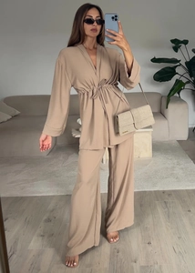 Detail of V-neck tie-up long sleeve top and high waist wide leg pants in beige